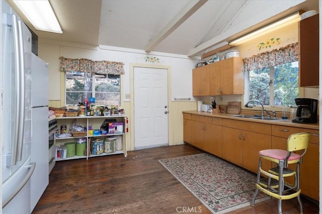 kitchen with vaulted ceiling with beams, white refrigerator, dark hardwood / wood-style floors, and sink