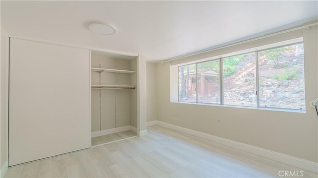 unfurnished bedroom featuring a closet and light wood-type flooring