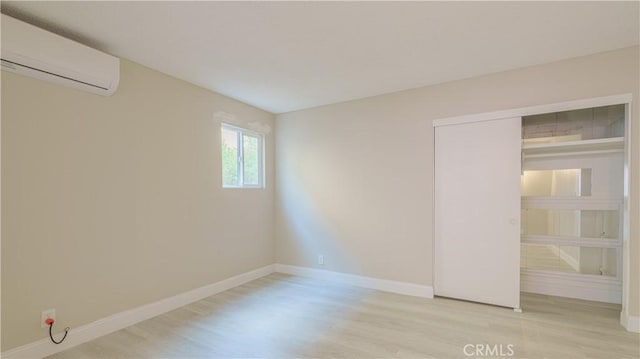 unfurnished bedroom featuring a wall mounted air conditioner and a closet