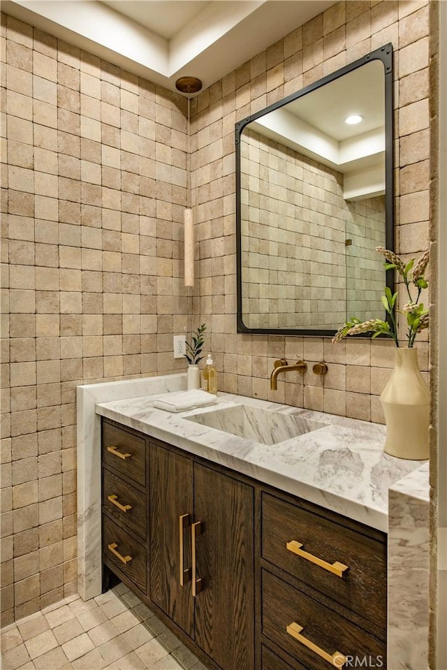 bathroom with tile patterned flooring, vanity, and tile walls