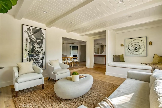 living room with beamed ceiling and wood-type flooring