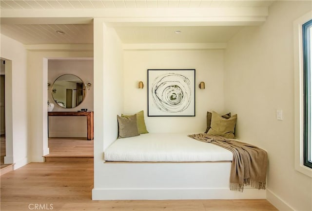 bedroom with wood-type flooring and beam ceiling