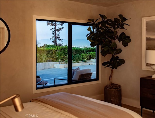 bedroom featuring a mountain view, access to outside, and multiple windows