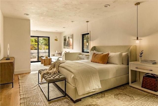 bedroom featuring access to exterior and light hardwood / wood-style flooring