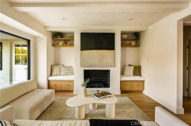 living room featuring beamed ceiling and wood-type flooring