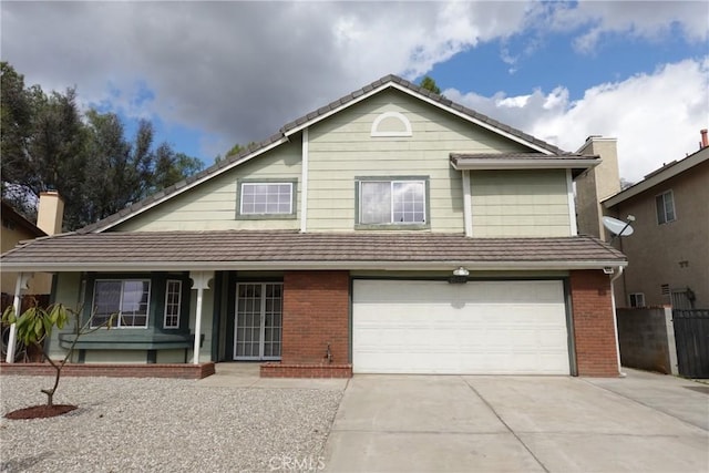 view of front of property with driveway, a garage, fence, and brick siding