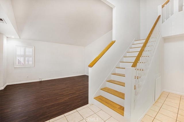 stairway with tile patterned floors, visible vents, and baseboards