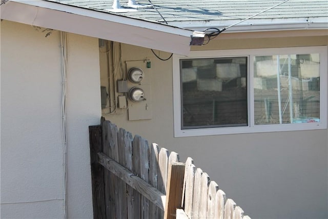 details featuring stucco siding and fence