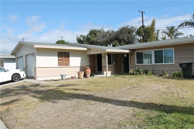 single story home with a garage and a front lawn