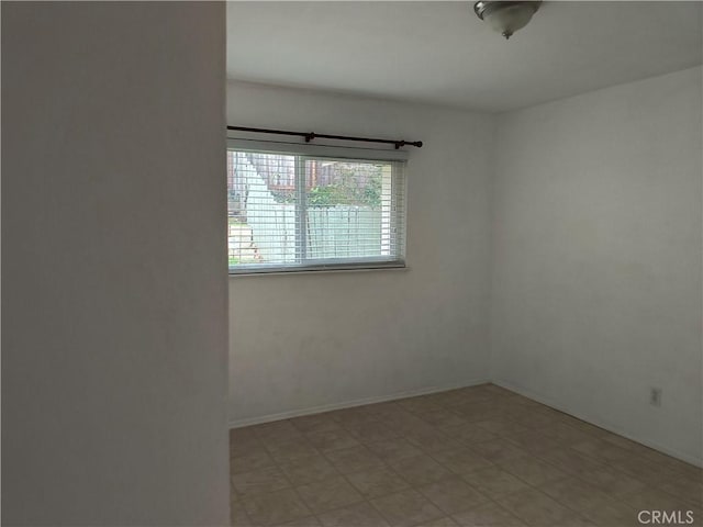 unfurnished room with baseboards