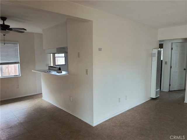 empty room with a healthy amount of sunlight, baseboards, and a ceiling fan