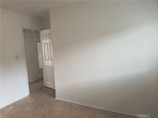 spare room with light floors and baseboards