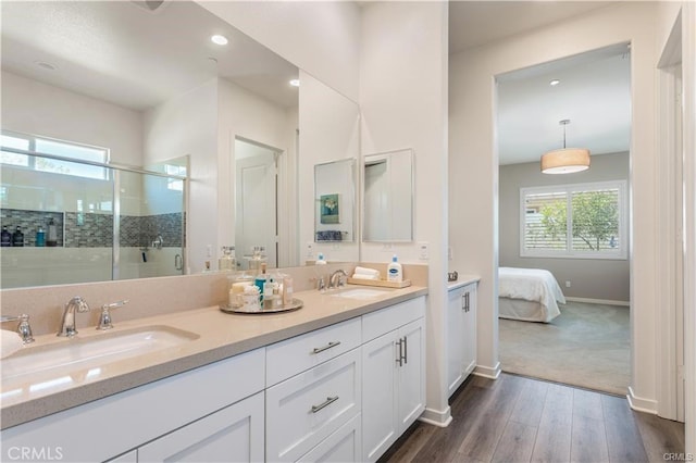 bathroom with wood-type flooring, vanity, and an enclosed shower