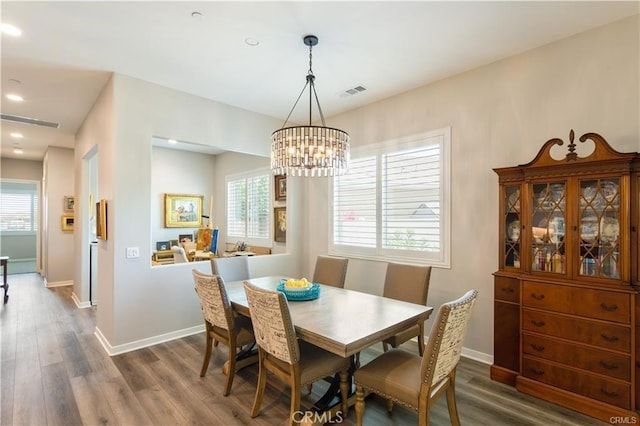 dining space with a notable chandelier and dark hardwood / wood-style flooring