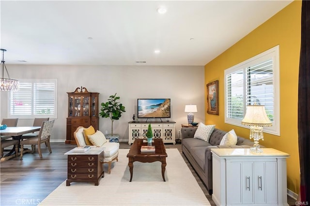 living room featuring an inviting chandelier and hardwood / wood-style flooring