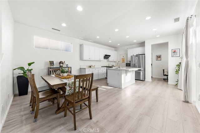 dining area with light hardwood / wood-style flooring and sink