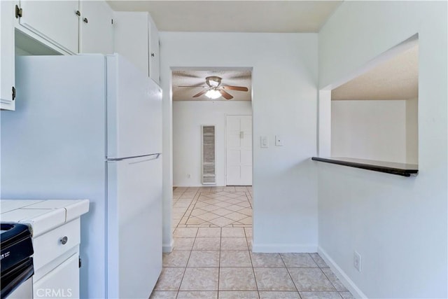 kitchen with white cabinets, electric range, white fridge, and tile counters