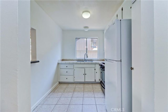 kitchen with white cabinetry, sink, white fridge, and stainless steel range with electric stovetop