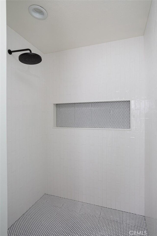 interior details featuring tiled shower