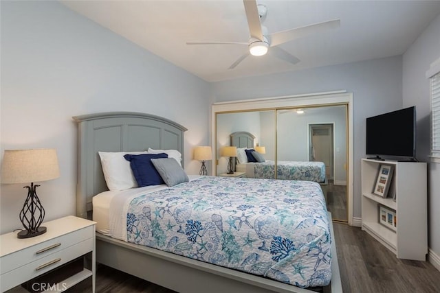 bedroom with ceiling fan, dark wood-type flooring, and a closet