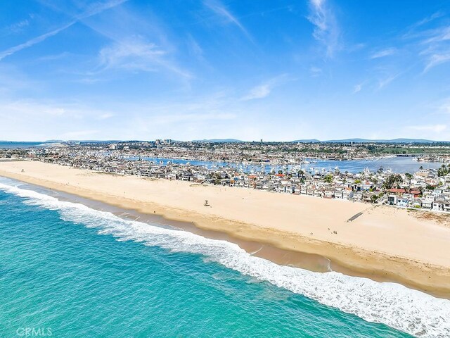 drone / aerial view with a water view and a beach view