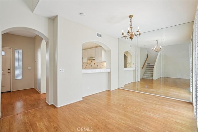 interior space with light wood-type flooring and an inviting chandelier