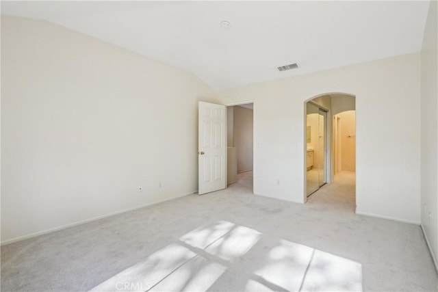 unfurnished bedroom featuring light carpet and vaulted ceiling