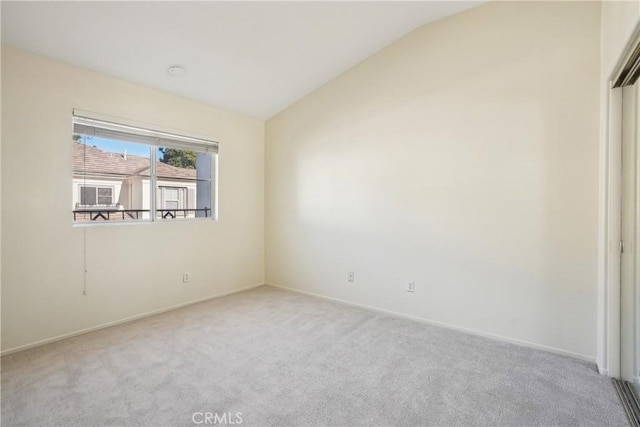 unfurnished bedroom with light colored carpet and vaulted ceiling