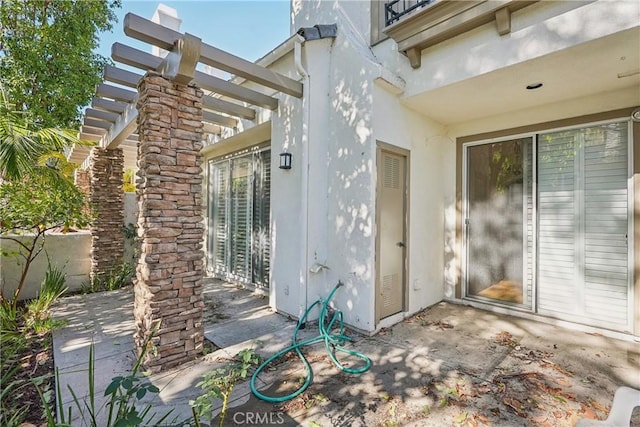 doorway to property featuring a patio and a pergola