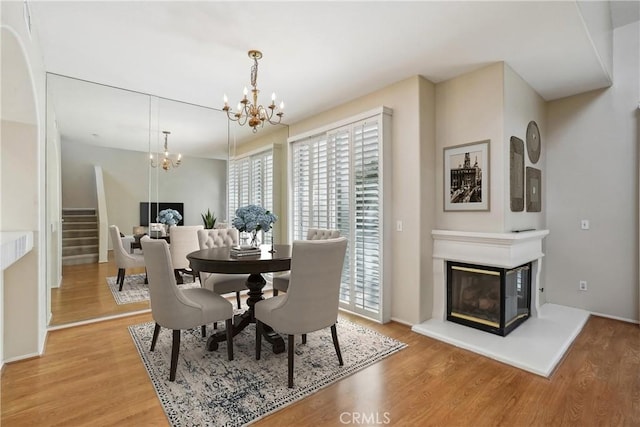 dining area with wood-type flooring and an inviting chandelier