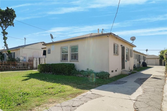 view of property exterior featuring a garage, an outdoor structure, and a lawn