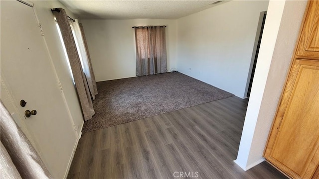 empty room with dark hardwood / wood-style flooring