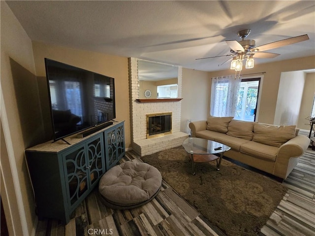 living room featuring ceiling fan and a fireplace