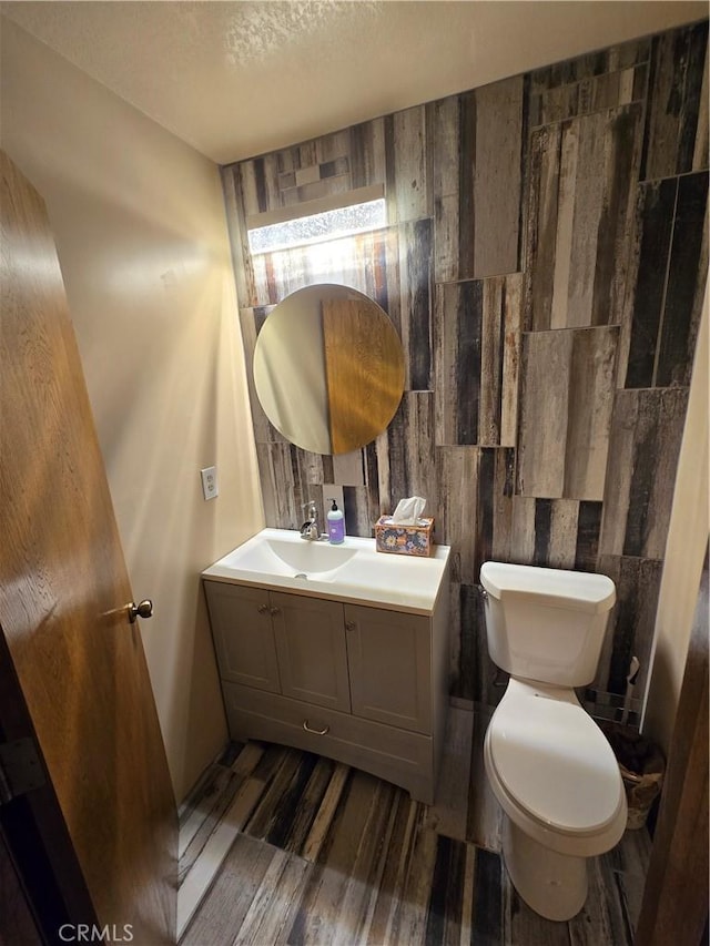 bathroom featuring hardwood / wood-style floors, vanity, toilet, and a textured ceiling