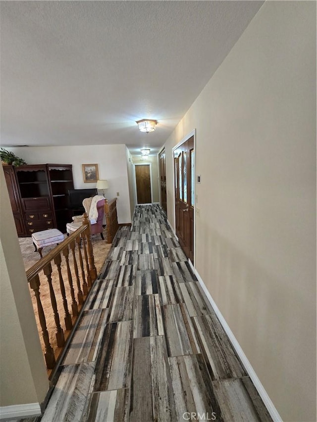 corridor featuring dark hardwood / wood-style floors and a textured ceiling