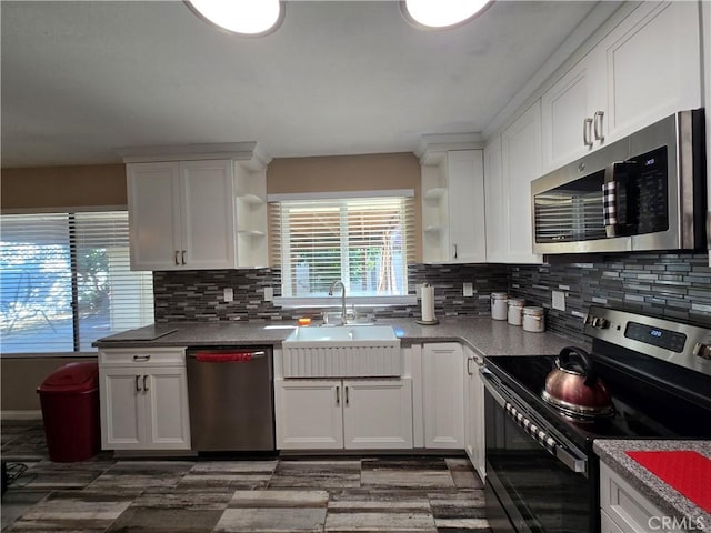 kitchen with sink, white cabinetry, stainless steel appliances, and tasteful backsplash