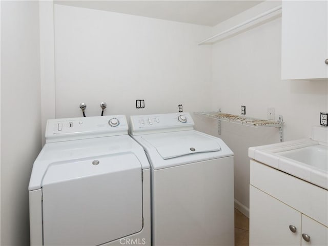 clothes washing area featuring cabinets and independent washer and dryer