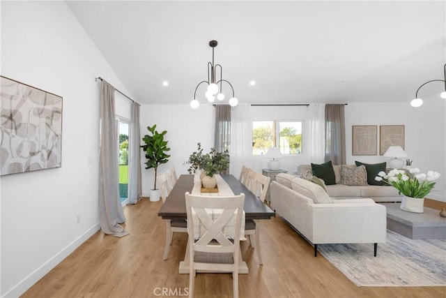 dining room with a healthy amount of sunlight, a notable chandelier, and light hardwood / wood-style floors