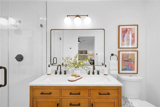 bathroom featuring toilet, vanity, ceiling fan, and a shower with shower door