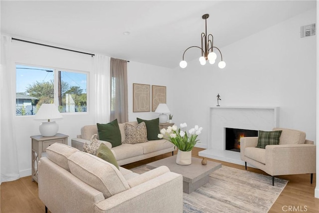 living room featuring light wood-type flooring and an inviting chandelier