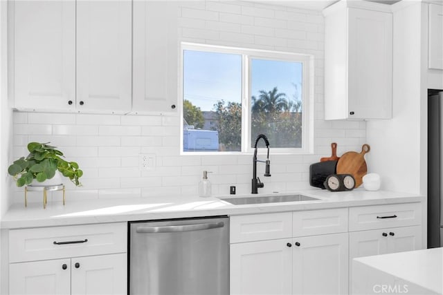 kitchen with white cabinets, appliances with stainless steel finishes, decorative backsplash, and sink