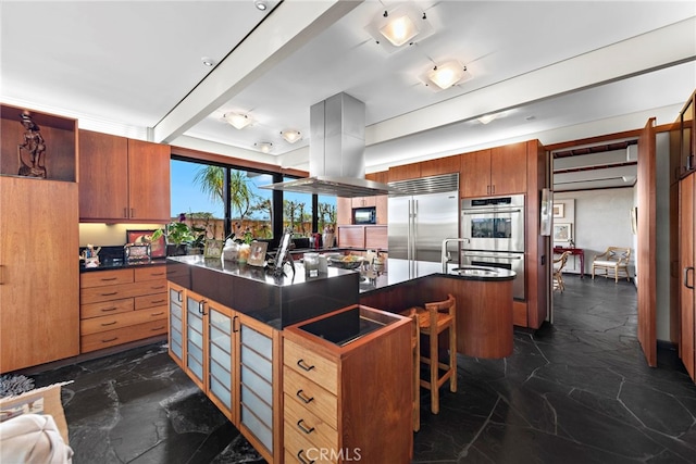 kitchen with beam ceiling, stainless steel appliances, island exhaust hood, a breakfast bar area, and a center island with sink