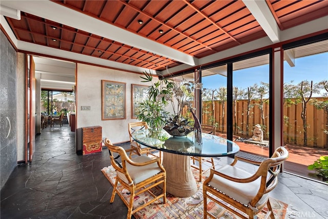 sunroom featuring beam ceiling, a healthy amount of sunlight, and wood ceiling