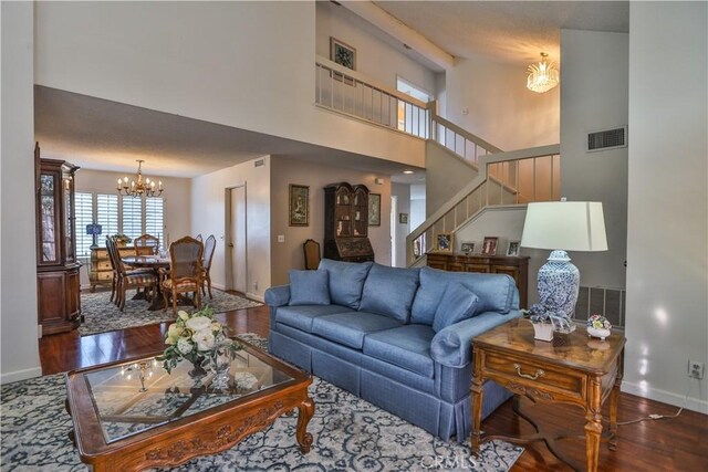 living room with dark hardwood / wood-style flooring and an inviting chandelier