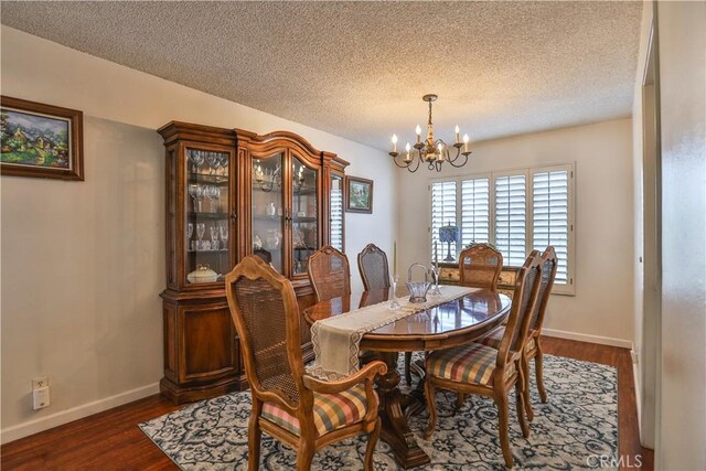 dining space featuring dark hardwood / wood-style flooring, a textured ceiling, and a chandelier