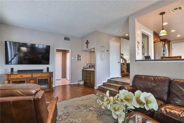 living room featuring a textured ceiling and light hardwood / wood-style floors