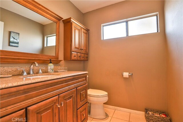 bathroom with tile patterned flooring, plenty of natural light, vanity, and toilet