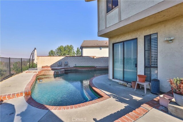 view of swimming pool featuring an in ground hot tub and a patio