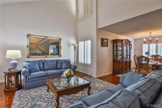 living room with dark hardwood / wood-style flooring, an inviting chandelier, and plenty of natural light