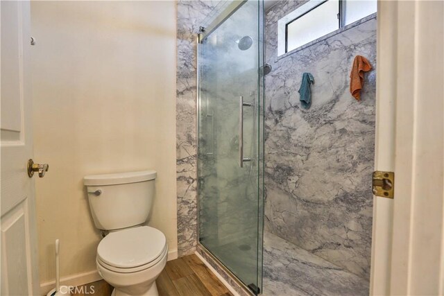 bathroom with walk in shower, hardwood / wood-style flooring, and toilet